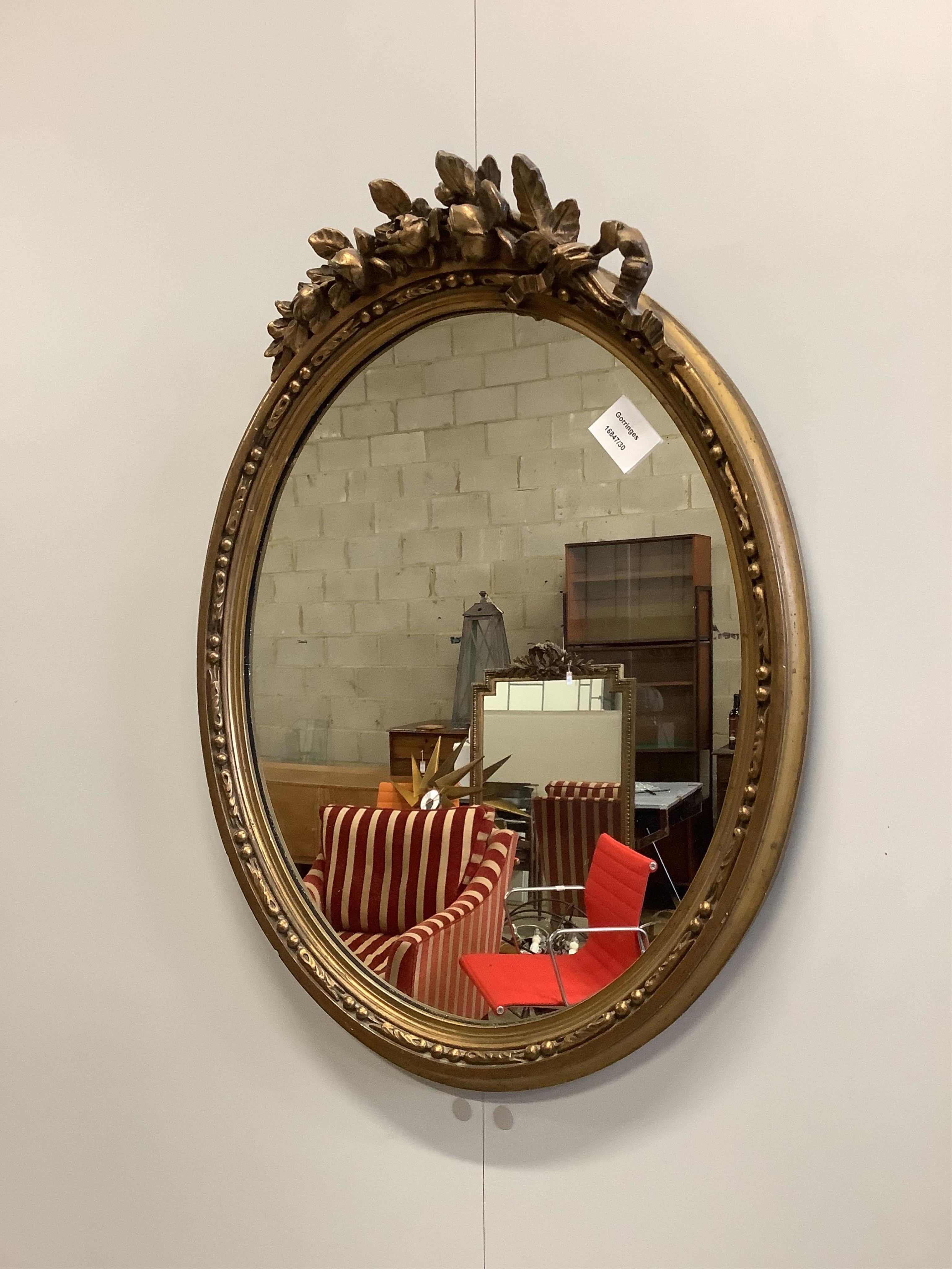 An oval gilt framed wall mirror, width 47cm, height 60cm. Condition - fair